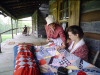 Docents work stitch a quilt on the porch of Historic Collinville’s Dog Trot House.