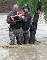 U.S. Army Sgt. Robert Huff, of Erlanger, KY, and U.S. Army Cpl. Patrick O’ Rourke, Front Royal, VA, rescue an Afghan child from encroaching flood waters in the Nari Shahi village in the Beshood District of eastern Afghanistan’s Nangarhar province July 28th. (U.S. Army courtesy photo)