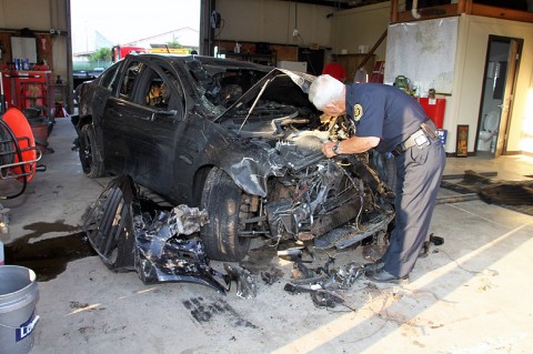 Photo-Officer Bechtold inspecting Amy Fetter’s burned vehicle.