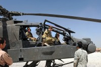 Chief Warrant Officer 2 Elizabeth Kimbrough - an AH-64 Apache pilot - and Capt. Donna Buono (middle) - the commander of Company B, 3rd Battalion, 101st Aviation Regiment, and an AH-64 Apache pilot - introduce Afghan air force Maj. Gen. Abdul Razik Sherzai, the commander of the Kandahar Air Wing, to the helicopter during the general's visit with Task Force Thunder here April 2nd. (Photo by Sgt. 1st Class Stephanie Carl)