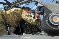 Capt. Donna Buono (left), the commander of Company B, 3rd Battalion, 101st Aviation Regiment, and an AH-64 Apache pilot, introduces Afghan Air Force Maj. Gen. Abdul Razik Sherzai, the commander of the Kandahar Air Wing, to the helicopter during the general's visit with Task Force Thunder here April 2nd. (Photo by Sgt. 1st Class Stephanie Carl)