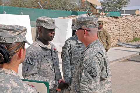 Col. Michael Peterman, 101st Sustainment Brigade commander, shakes hands with Staff Sgt. Kofi Nyarko, 101st Sustainment Brigade Support Operations, after he receives his Bronze Star Medal at the unit’s End of Tour Awards Ceremony. (Photo by Sgt. 1st Class Peter Mayes)