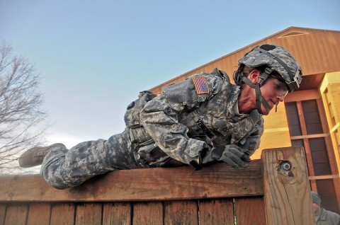 Pfc. Nicole Veneziano, a communications specialist with Headquarters and Headquarters Company, 2nd Brigade Combat Team, 101st Airborne Division (Air Assault), climbs over a six foot wall during a combat focused physical training event honoring Strike’s fallen hero Staff Sgt. James P. Hunter, the brigade’s combat correspondent who was killed by an IED in southern Afghanistan, June 18th, 2010. Veneziano said that the PT was really demanding and she wanted to quit, but was inspired to continue because of Hunter and his story. (U.S. Army photo by Sgt. Joe Padula, 2nd BCT PAO, 101st Abn. Div.)