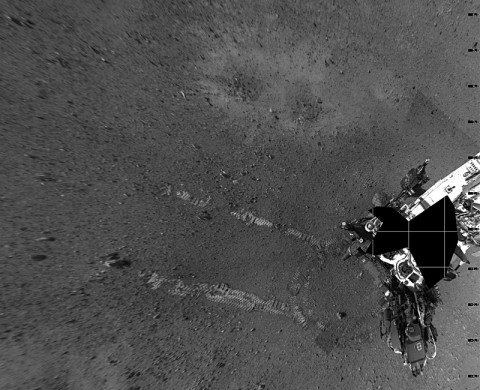 This overhead view shows evidence of a successful first test drive for NASA's Curiosity rover. On Aug. 22nd, 2012, the rover made its first move, going forward about 15 feet (4.5 meters), rotating 120 degrees and then reversing about 8 feet (2.5 meters). Curiosity is now about 20 feet (6 meters) from its landing site, named Bradbury Landing. This mosaic from the rover's Navigation camera is made up of 23 full-resolution frames, displayed in a vertical projection. (Image credit: NASA/JPL-Caltech)