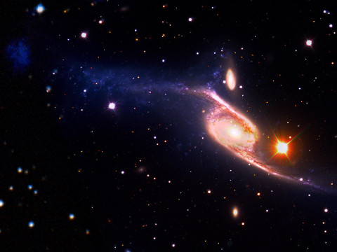 This composite of the giant barred spiral galaxy NGC 6872 combines visible light images from the European Southern Observatory's Very Large Telescope with far-ultraviolet (1,528 angstroms) data from NASA's GALEX and 3.6-micron infrared data acquired by NASA's Spitzer Space Telescope. (Image credit: NASA's Goddard Space Flight Center/ESO/JPL-Caltech/DSS)