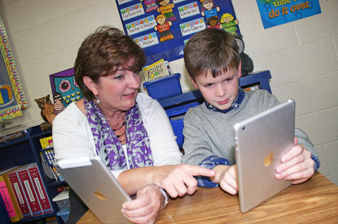 Second Grade Teacher, Frances Traughber works with Cooper Wallace on a spelling exercise using the iPad mini.