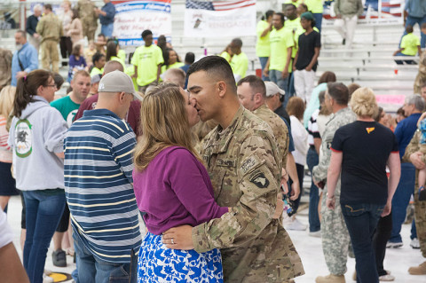 Spc. Ross Michael Noffisinger, Headquarters and Headquarters Company, 1st Battalion, 101st Combat Aviation Brigade, 101st Airborne Division (Air Assault), kisses his wife during a welcome home ceremony at Fort Campbell, KY, May 14th, 2013. (U.S. Army photo by Sgt. Duncan Brennan, 101st CAB Public Affairs)