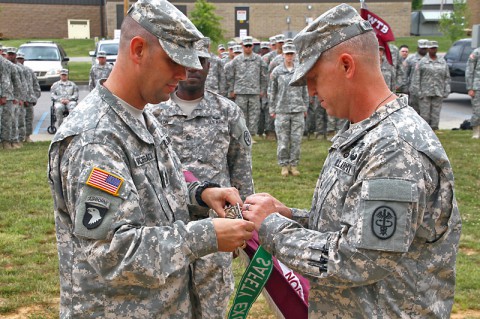 Fort Campbell Warrior Transition Battalion acting command sergeant major 1st Sgt. Daniel Munchbach and commander Lt Col. Bryan Walrath pin the Department of the Army Safety Excellence Streamer to the WTB colors during a ceremony July 3, 2014. (U.S. Army photo by Sgt. Eric Lieber)