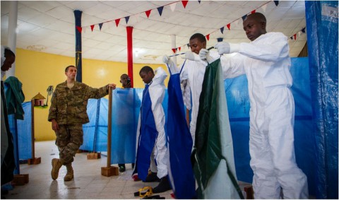 Senior Airman Joshua Douglass, an aerospace medical technician, watches as health care workers properly put on their personal protective equipment in Buchanan City, Nov. 21, 2014. Douglass is a part of the mobile training team that travels throughout Liberia to remote areas to train health care workers about Ebola and how to work in an Ebola treatment unit. Operation United Assistance is a Department of Defense operation in Liberia to provide logistics, training and engineering support to U.S. Agency for International Development-led efforts to contain the Ebola virus outbreak in western Africa. (Staff Sgt. Terrance D. Rhodes/U.S. Army)
