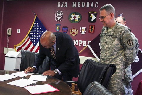 Blanchfield Army Community Hospital commander Col. George N. Appenzeller and Dr. Frank S. Royal Jr., Meharry Medical College's vice dean of clinical affiliations, sign a formal agreement Friday, creating a partnership for regular clinical rotations at the Fort Campbell hospital. (U.S. Army photo by Courtney Wittmann)