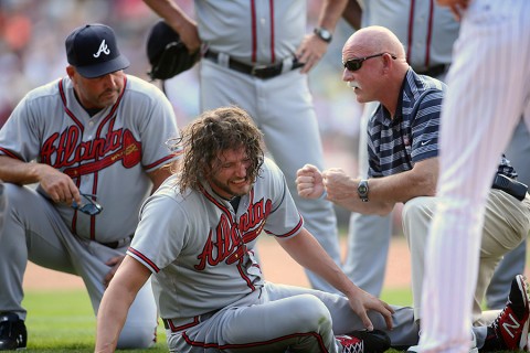 Atlanta Braves relief pitcher Jason Grilli (center) is attended to by Atlanta Braves manager Fredi Gonzalez (left) and team trainer Jeff Porter (right), and teammates after being injured during the ninth inning against the Colorado Rockies at Coors Field. The Rockies won 3-2. (Chris Humphreys-USA TODAY Sports)