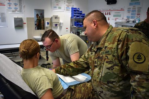 Specialist Bowman (center), a medic with the 230th Engineer Battalion, 194th Engineer Brigade, Tennessee Army National Guard, administers an IV while Captain Henry (right), a physician assistant with the Tennessee Army National Guard medical detachment supervises during Operation Resolute Castle on May 26, 2016 at Novo Selo Training Area. During the training exercise, Cpt. Henry created an environment where soldiers under his command were required to evaluate patients and administer IVs. (1st Lt. Matthew Gilbert, 194th Engineer Brigade) 