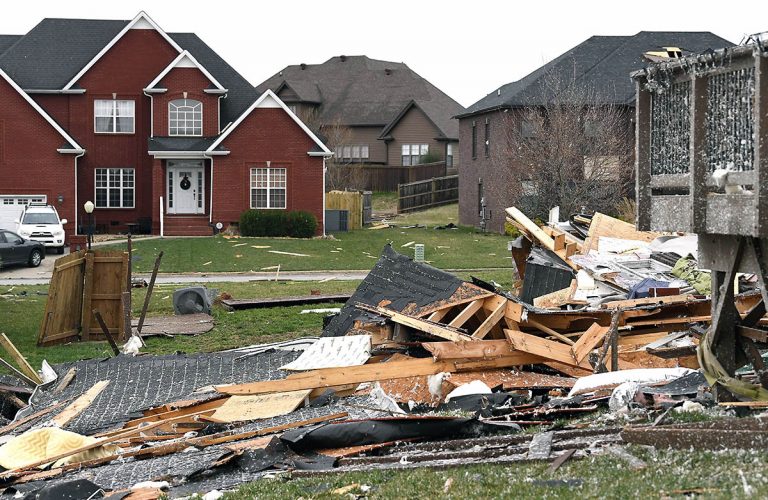Debris is strewn throughout the neighborhood Sunday morning after a