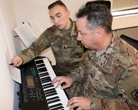 Spc. Walter Reuter, a pianist with the 101st Airborne Division Band, helps Lt. Col. Arnaldo Huertas, a Soldier with the Fort Campbell Warrior Transition Battalion, play through a challenging section of a song during a music lesson, Feb. 1. The battalion's Occupational Therapy department partners with the 101st Airborne Division (Air Assault) Band to provide musical instruction to Soldiers at the WTB. (U.S. Army photo by Maria Yager)