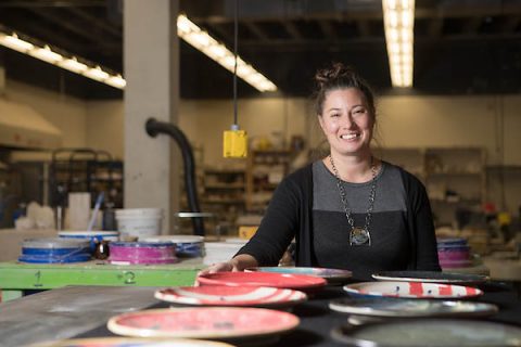 APSU grad student Melody Shipley stands with plates made as part of her art therapy project. 