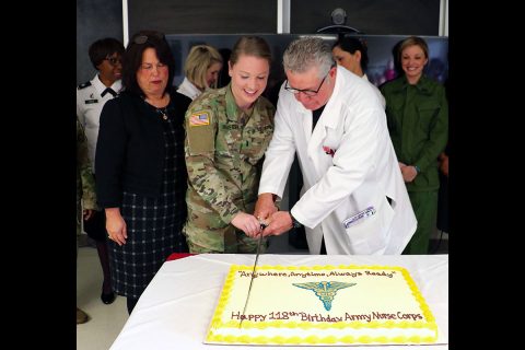 Blanchfield's most experienced nurse Jodie Hannes, a nursing supervisor, and youngest nurse 1st Lt. Nora Krueger, who recently reported to the hospital, cut a cake celebrating the 118th birthday of the Army Nurse Corps. A saber is used representing the Army Nurse Corps' commitment to military service so our nation may live in peace. (U.S. Army photo by Maria Yager)