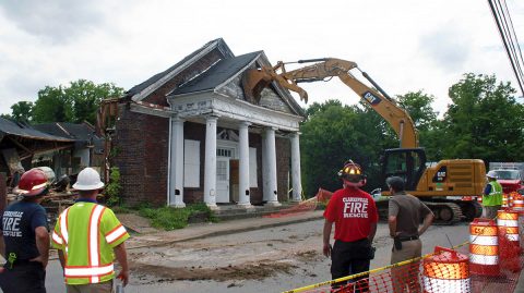 A Clarksville Street Department track hoe pushes down the damaged front of the old Wesley Chapel Christian Methodist Episcopal Church near downtown during a search Thursday.