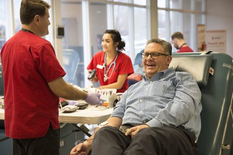 Thomas Brown finishes giving blood with American Red Cross staff member Alex White. (Amanda Romney, American Red Cross)