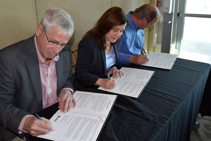 (from left) TWRA Executive Director Bobby Wilson, Oak Ridge Office of Environmental Management Acting Manager Laura Wilkerson, and Oak Ridge National Laboratory Site Office Manager Johnny Moore sign an agreement that lays the groundwork to transfer more than 3,500 acres of scenic East Tennessee land from the U.S. Department of Energy to the state of Tennessee.