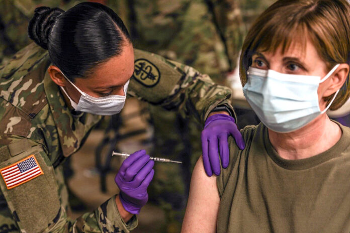 Staff Sgt. Brenda Collins, medical specialist, from Carl R. Darnall Army Medical Center administers the COVID-19 vaccination to a patient during the phase one process Dec.15, 2020 at on Fort Hood, Texas. Distribution of the vaccine will be conducted in phases based on CDC guidance. The vaccine is stored and distributed under various controls to ensure the safety of the recipient. (U.S. Army photo by Staff Sgt. Desmond Cassell)