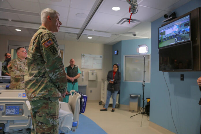 Blanchfield Army Community Hospital Commander Col. Vincent B. Myers addresses a wall-mounted video camera in one of the hospital’s Intensive Care Unit suites on Fort Campbell, Kentucky, to communicate with the Defense Health Agency’s Virtual Medical Operations Center, located at Naval Medical Center San Diego, during a demonstration of the Joint Tele Critical Care Network, March 24. The JTCCN virtually integrates highly skilled critical care physicians, or intensivists, from DHA medical centers, or “hubs”, like NMCSD and Brook Army Medical Center, for consultation with “satellite” intensive care units at nearly 20 military treatment facilities worldwide.