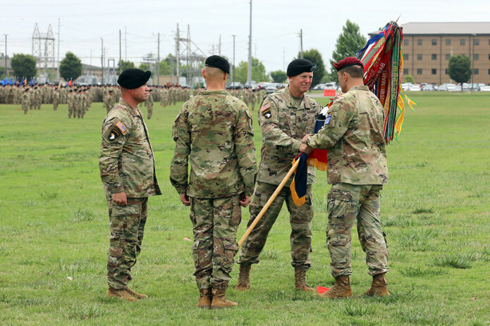Maj. Gen. JP McGee, outgoing commander of the 101st Airborne Division (Air Assault), hands the division colors to Lt. Gen. Christopher Donahue, commander of XVIII Airborne Corps, during the division Change of Command ceremony at Fort Campbell, Ky., July 20, 2023. McGee relinquished command to incoming commander Maj. Gen. Brett Sylvia during the ceremony. (Pfc. Brianna Frank, 40th Public Affairs Detachment)