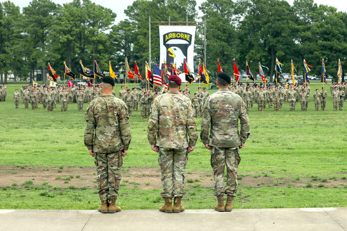 Lt. Gen. Christopher Donahue, commander of XVIII Airborne Corps, Maj. Gen. JP McGee, outgoing commander of the 101st Airborne Division (Air Assault), and Maj. Gen. Brett Sylvia, incoming commander, watch the division colors come together during the division Change of Command ceremony at Fort Campbell, Ky., July 20, 2023. The change of command ceremony is a tradition where the outgoing commander symbolically relinquishes command and authority by passing the division's colors to the presiding officer, who then hands the colors to the incoming commander, thus beginning a new era of leadership for the incoming commander and the division as a whole. (Sgt. Andrea Notter, 101st Airborne Division)